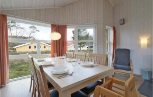 a dining room with a table and chairs and a large window at Frische Brise 9 - Dorf 2 in Priwall