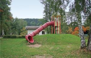 einen Spielplatz mit einer roten Rutsche in einem Park in der Unterkunft Awesome Home In Lnebach With 7 Bedrooms, Sauna And Wifi in Lünebach