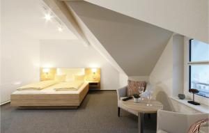 ダゲビュルにあるAmazing Apartment In Dagebll With Wifiのベッドルーム1室(ベッド1台、テーブル、椅子付)