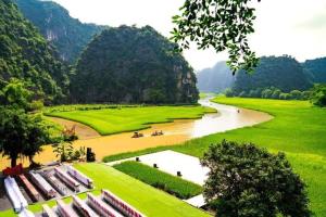 Blick auf einen Fluss neben einem üppigen grünen Feld in der Unterkunft Nam Nhung Tam Coc Homestay in Ninh Bình