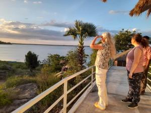 two women standing on a balcony looking at the water at Oruwa Boutique Villas in Arugam Bay