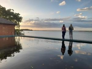 two people standing next to a pool of water at Oruwa Boutique Villas in Arugam Bay
