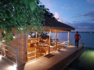 a man walking on the dock of a house on the water at Oruwa Boutique Villas in Arugam Bay