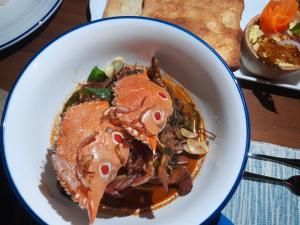 a white bowl of food with meat and mushrooms at Oruwa Boutique Villas in Arugam Bay