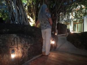 a woman with long blue hair walking along a wall at Oruwa Boutique Villas in Arugam Bay