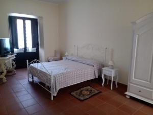 a bedroom with a white bed and a window at Casa Cecilia in Gallico Marina