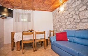 uma sala de estar com uma mesa e um sofá azul em 2 Bedroom Stunning Home In Herceg Novi em Sitnica