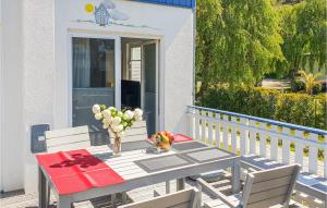 - une table avec un vase de fleurs sur une terrasse couverte dans l'établissement Gorgeous Home In Breege-juliusruh With Kitchen, à Juliusruh