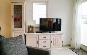 a living room with a flat screen tv on a cabinet at Gorgeous Home In Breegejuliusruh in Juliusruh