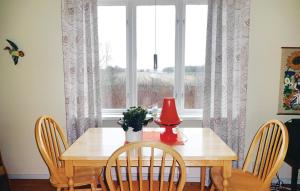 uma mesa de jantar com um candeeiro vermelho e uma janela em 2 Bedroom Amazing Home In Slvesborg em Möllebjörke
