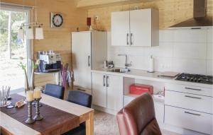una cocina con armarios blancos y una mesa con sillas. en Lovely Home In Wilsum With Wifi, en Wilsum