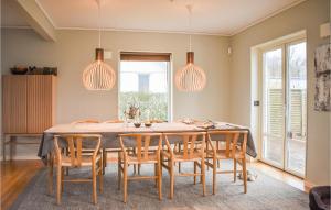 jadalnia ze stołem, krzesłami i światłami w obiekcie Nice Home In Kivik With Wifi w mieście Kivik