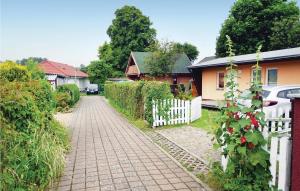 a brick driveway leading to a house with a white fence at Holiday Home Dranske Alte Gärtnerei in Dranske