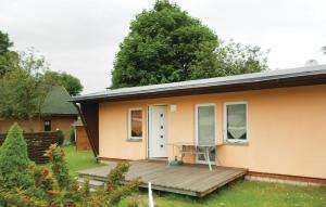 a house with a wooden porch and a table on a deck at Holiday Home Dranske Alte Gärtnerei in Dranske