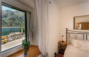 a bedroom with a large window with a view of the water at Lovely Home In Kotor With Wifi in Kotor