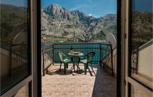 a table and chairs on a balcony with mountains at Lovely Home In Kotor With Wifi in Kotor