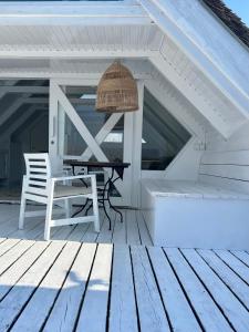 einen Tisch und einen Stuhl auf einer Holzterrasse in der Unterkunft Seehütte Strandhaus direkt im Neusiedler See in Rust