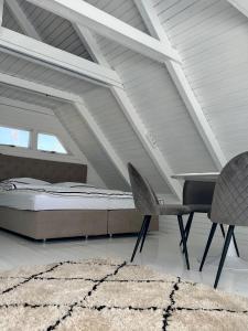 - une chambre avec un lit, une chaise et un tapis dans l'établissement Seehütte Strandhaus direkt im Neusiedler See, à Rust
