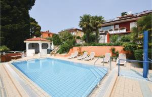 a swimming pool with chairs and a house at Awesome Apartment In Portoroz With Outdoor Swimming Pool in Portorož