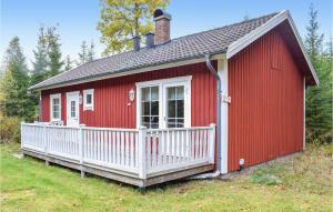 une petite maison rouge avec une véranda blanche dans l'établissement 2 Bedroom Lovely Home In Eksj, à Eksjö