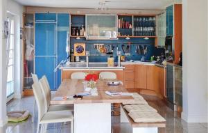 uma cozinha com paredes azuis e uma mesa e cadeiras de madeira em 3 Bedroom Amazing Home In Beckerwitzhohenkirchen em Hohenkirchen