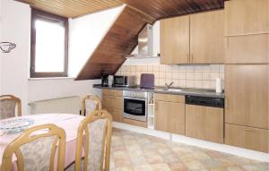 eine Küche mit Holzschränken und einem Tisch mit Stühlen in der Unterkunft 1 Bedroom Lovely Apartment In Lahnstein in Lahnstein