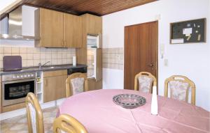 ein Esszimmer mit einem rosa Tisch und Stühlen in der Unterkunft 1 Bedroom Lovely Apartment In Lahnstein in Lahnstein + 8 Fotos