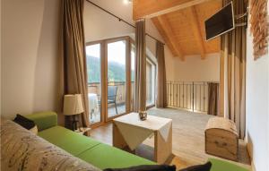 een woonkamer met een groene bank en een balkon bij 3 Bedroom Awesome Apartment In Kartitsch in Kartitsch