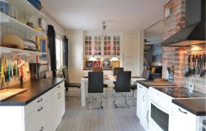 クリシャンスタードにあるNice Home In Kristianstad With 3 Bedrooms And Wifiのキッチン(白いキャビネット、黒い椅子とテーブル付)