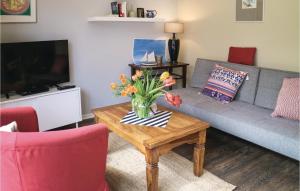 ein Wohnzimmer mit einem Sofa und einem Tisch mit Blumen darauf in der Unterkunft Awesome Apartment In Graal-mritz With 1 Bedrooms in Graal-Müritz