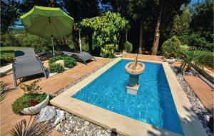 einen Pool mit Sonnenschirm im Hinterhof in der Unterkunft Cozy Apartment In Portoroz With Kitchen in Lucija