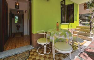 einen Tisch und Stühle in einem Zimmer mit grüner Wand in der Unterkunft Cozy Apartment In Portoroz With Kitchen in Lucija