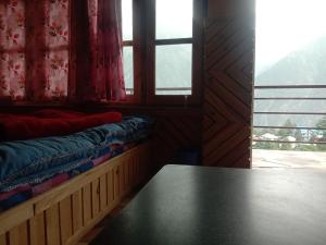 a room with a table in front of a window at MAA BHAGWATI HOME STAY in Kalpa