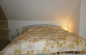 ein Schlafzimmer mit einem Bett mit einer Bettdecke darauf in der Unterkunft Awesome Apartment In Elmenhorst-lichtenhag, With Kitchenette in Elmenhorst