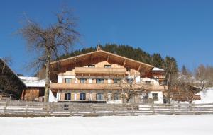 ein großes Holzhaus mit einem Zaun im Schnee in der Unterkunft Nice Apartment In Wagrain With 3 Bedrooms And Wifi in Wagrain