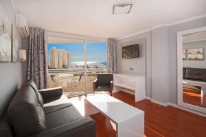 a living room with a couch and a view of a city at Olé Tropical Tenerife Adults Only in Playa de las Americas