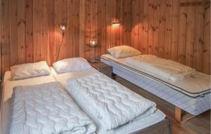Amazing Home In Hemsedal With Sauna في هيمسيدال: ثلاثة أسرة في غرفة بجدران خشبية