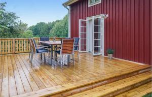 une terrasse avec une table et des chaises à côté d'un bâtiment rouge dans l'établissement Beautiful Home In Vrnamo With Wifi, à Värnamo