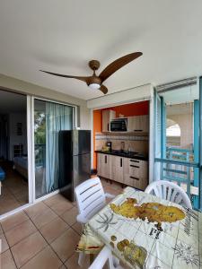 a kitchen and dining room with a table and chairs at Ti Studio Creole Mahogany in Sainte-Anne