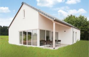 ein weißes Haus mit einer Terrasse und einem Tisch in der Unterkunft Ferienhaus 1 Wolfschlucht in Gondenbrett