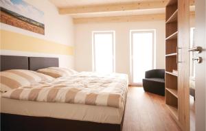 ein Schlafzimmer mit einem Bett und einem Stuhl sowie zwei Fenstern in der Unterkunft Ferienhaus 1 Wolfschlucht in Gondenbrett