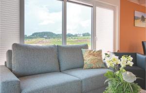 ein Sofa im Wohnzimmer mit einem großen Fenster in der Unterkunft Ferienhaus 1 Wolfschlucht in Gondenbrett