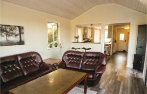 a living room with leather couches and a table at Lovely Home In Trosa With Kitchen in Trosa