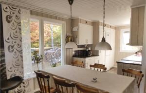 a kitchen with a table and chairs and a kitchen with a window at Lovely Home In Trosa With Kitchen in Trosa
