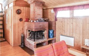 Una chimenea de ladrillo en una habitación con paredes de madera. en 2 Bedroom Beautiful Home In Trysil, en Trysil