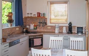 a kitchen with a sink and a table with chairs at 2 Bedroom Awesome Home In Woldegk in Woldegk