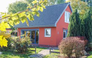 ein rotes Haus mit schwarzem Dach in der Unterkunft Ferienhaus Hildebrandshagen V in Woldegk