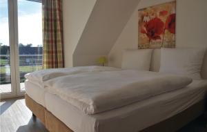 a bedroom with a large white bed with a window at Fewo Schloss Schwerin in Kaschow +5 photos