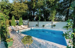 einen Pool in einem Garten mit Stühlen und einem Zaun in der Unterkunft Pet Friendly Apartment In Herceg Novi in Herceg-Novi