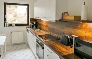 una cucina con armadi bianchi e ripiano in legno di Rehfugium a Bad Sachsa